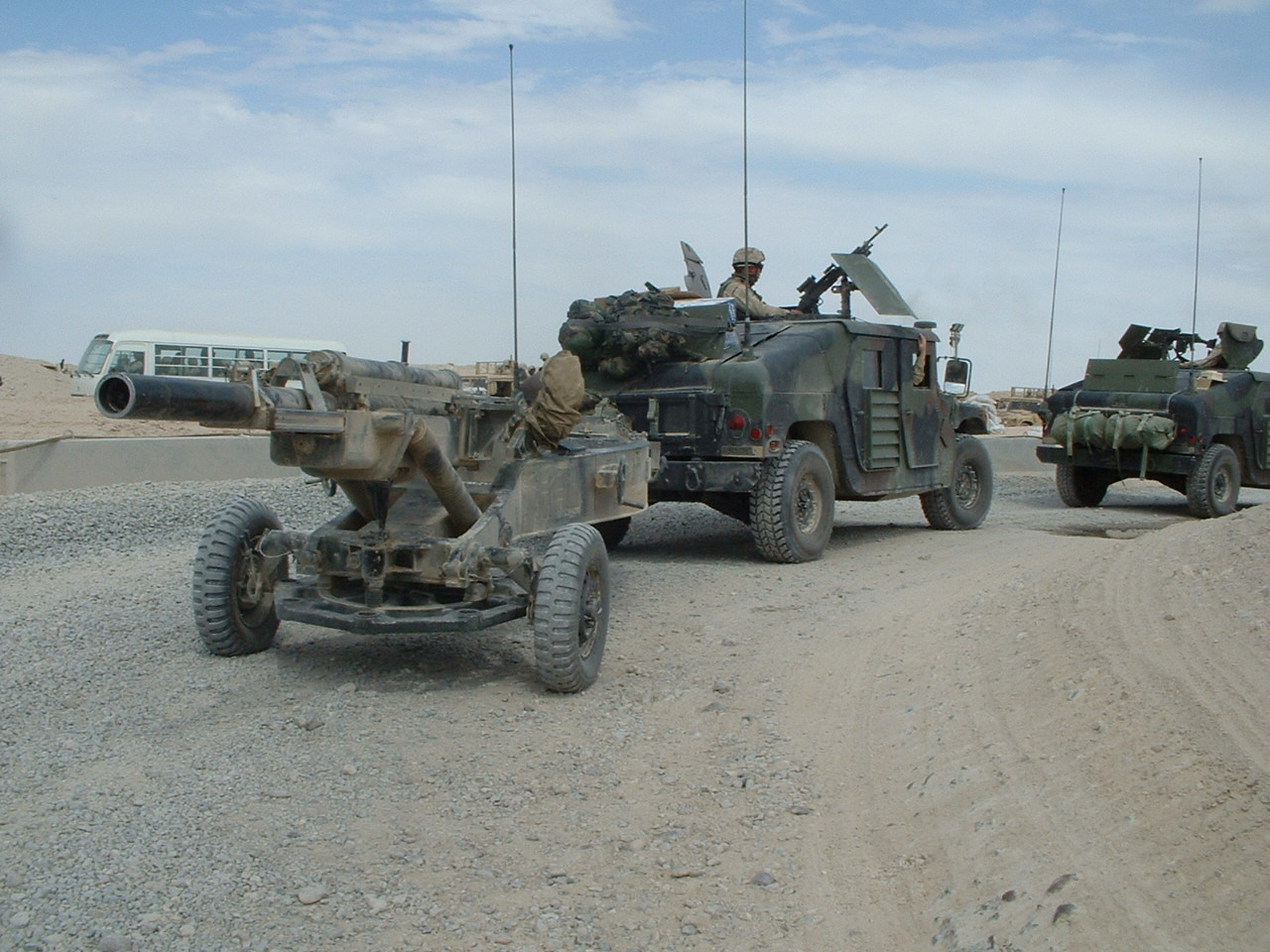 M1114 up-armoured HMMWV — A M102 Howitzer belonging to Battery A, 1-206th FA is towed north from Camp New York Kuwait on the convoy to Camp Taji by an M1114 Up-Armored HMMWV